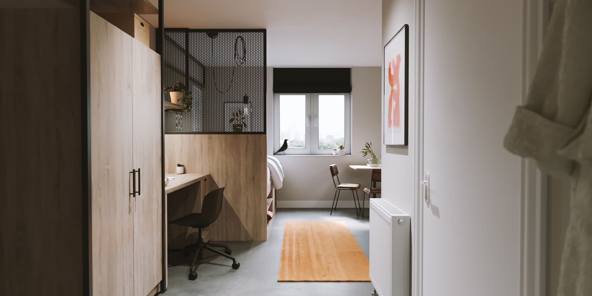 Entrance view of a modern studio apartment showing a wood wardrobe, a small desk area, and a window.