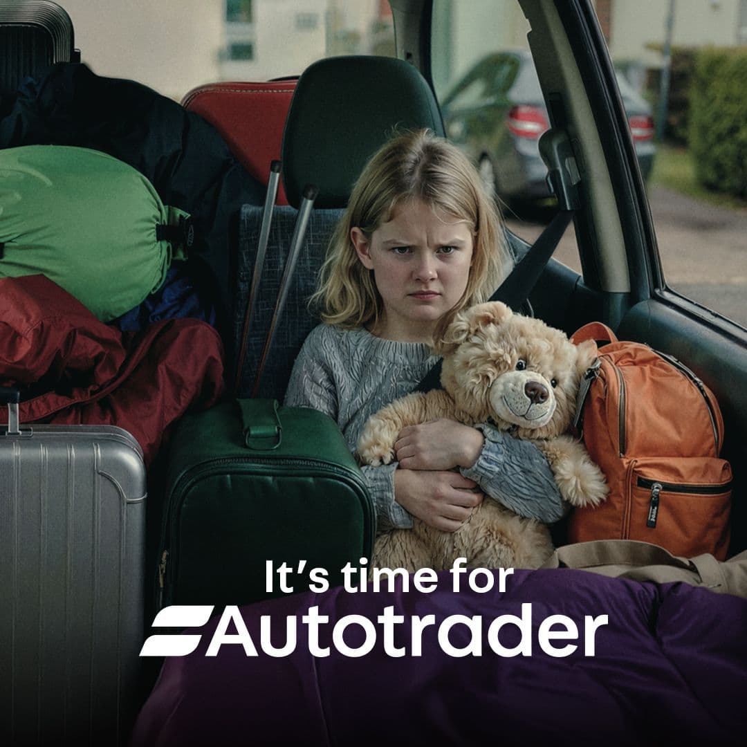 Girl looking annoyed squeezed in a packed car backseat with luggage and a teddy bear, with "It's time for Autotrader" text.