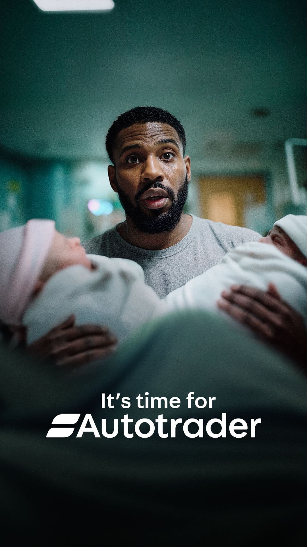 Shocked father holding newborn babies in a hospital setting with "It's time for Autotrader" text overlay.