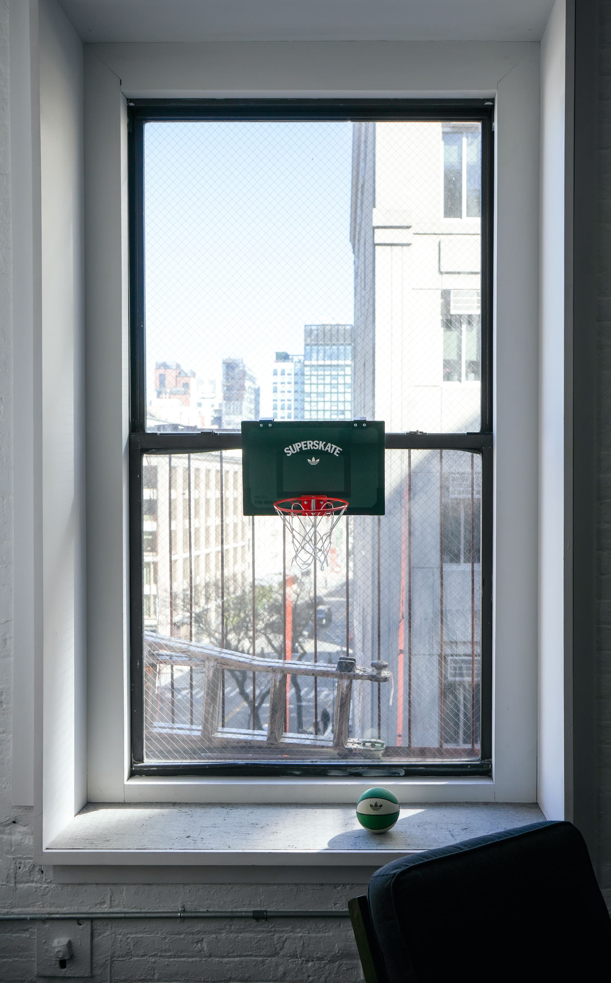 Mini basketball hoop on a window overlooking the city at the IMA New York office.