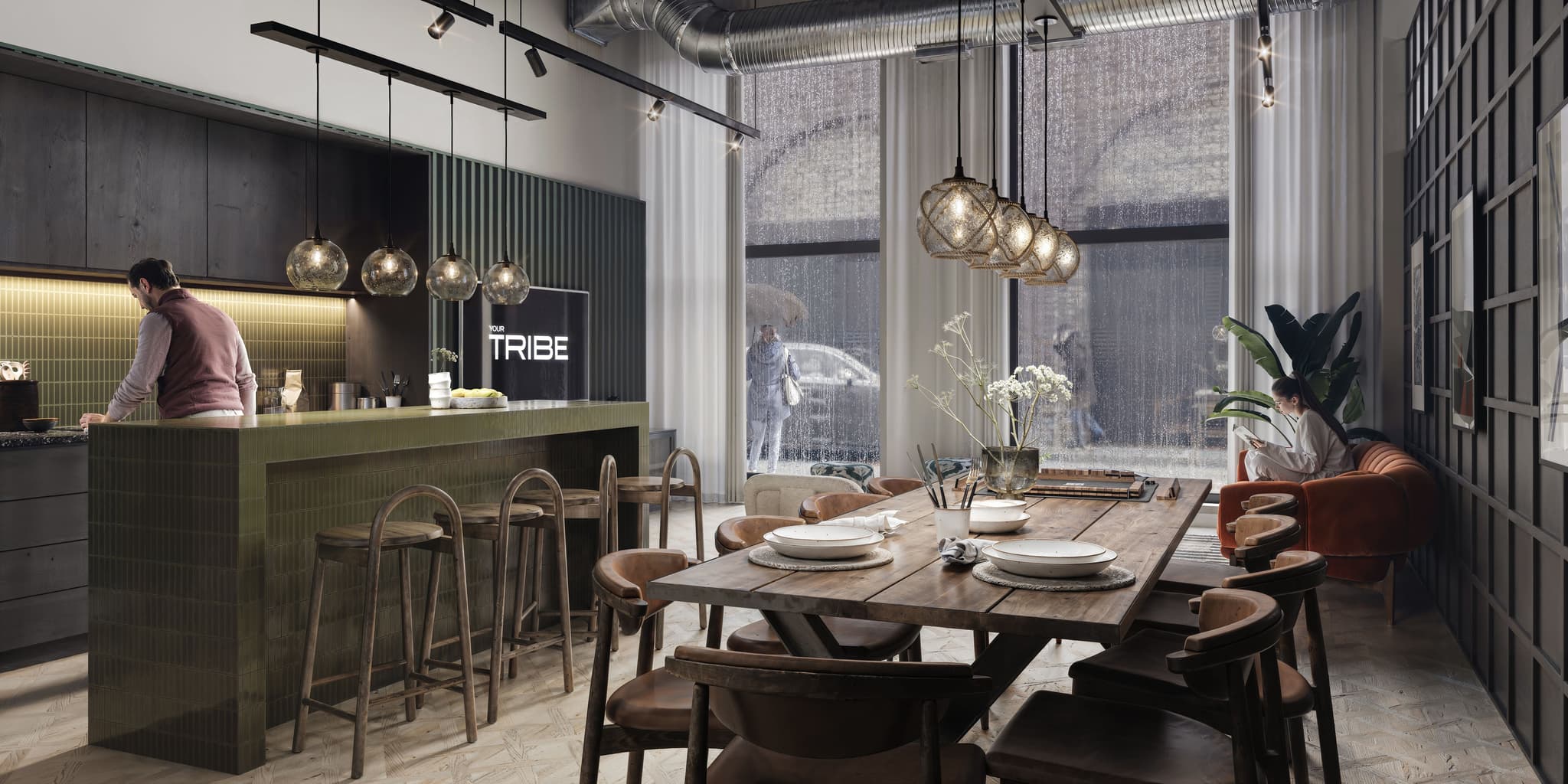 Communal kitchen and dining space with a green tiled breakfast bar, wooden dining table, and large rain-streaked windows.