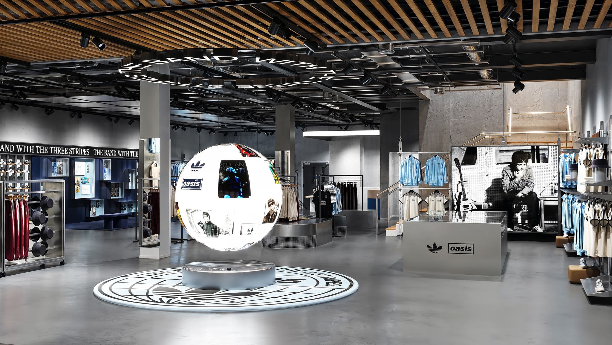 Wide view of an Adidas and Oasis collaborative retail store featuring a floating globe display and branded apparel.