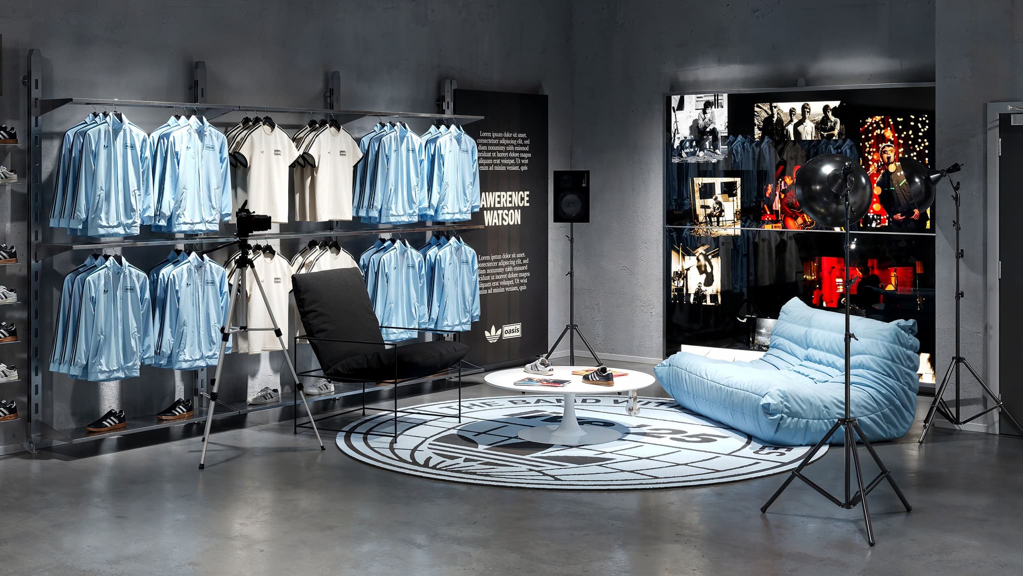 Lounge area in the Adidas Oasis store with a blue puffy sofa, round table, and a Lawrence Watson photo exhibition.