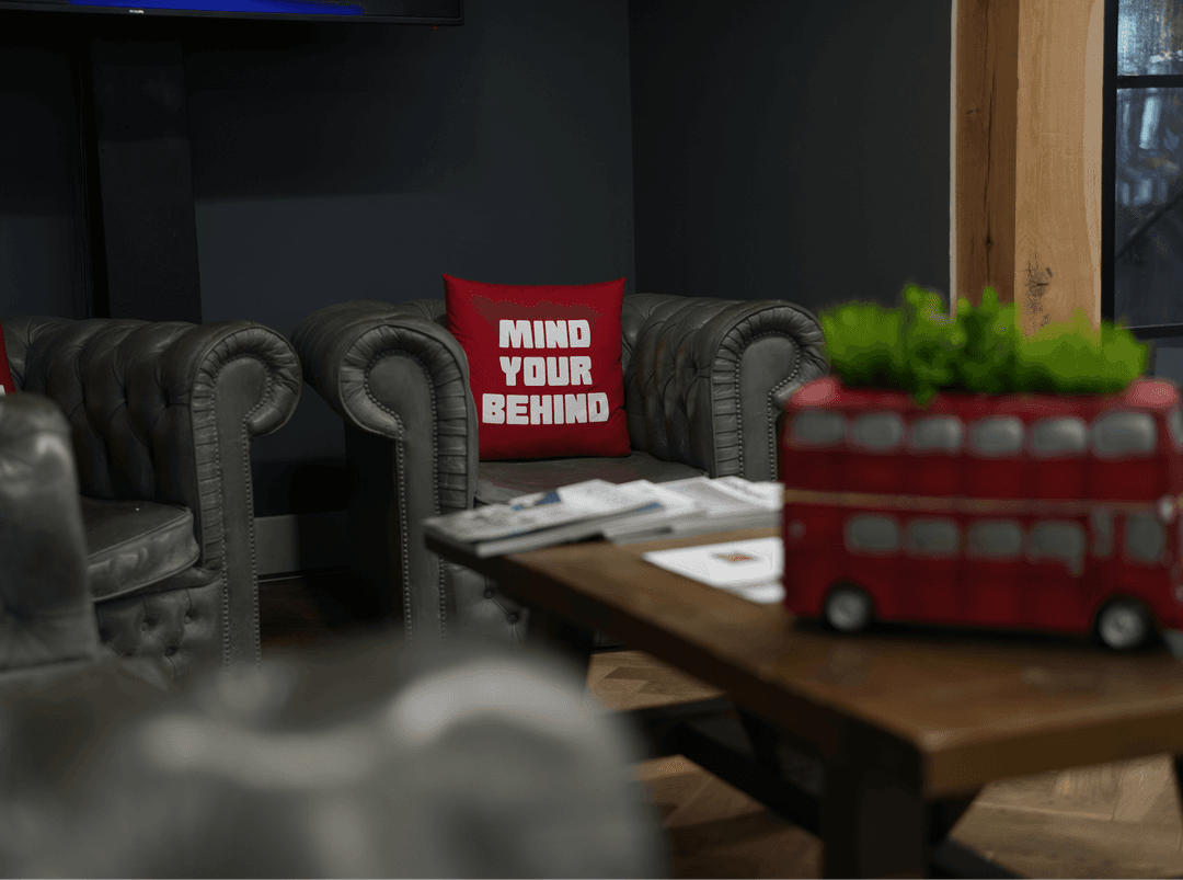 A cozy New York studio space featuring a tufted leather sofa and a London-themed decorative bus.