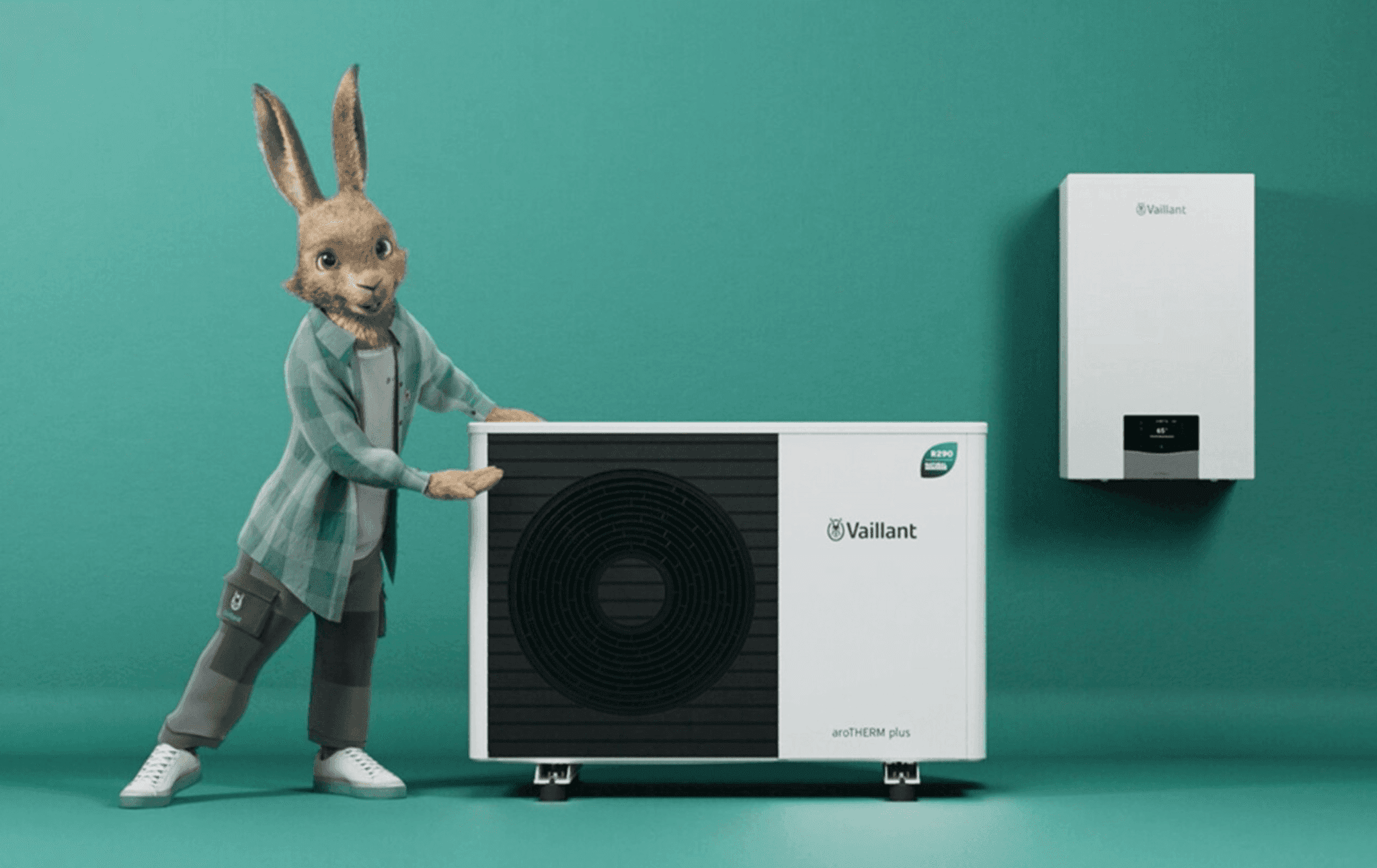 Vaillant hare mascot leaning on an aroTHERM plus heat pump, with a wall-mounted indoor unit in the background.