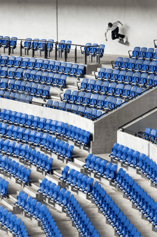 Close-up perspective of blue stadium chairs looking down the rows.