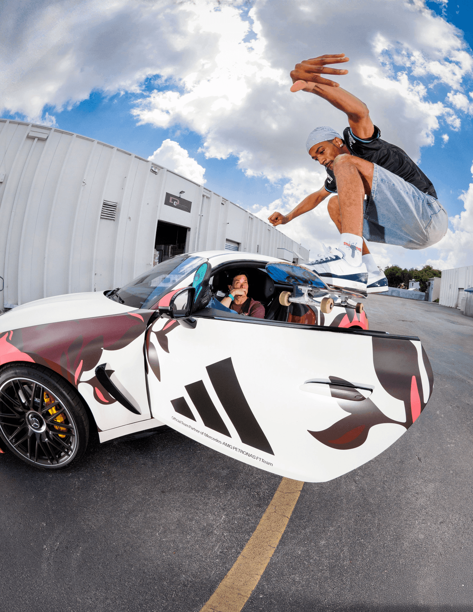 Tyshawn Jones performing a skateboard trick over a Mercedes-AMG sports car in Miami.