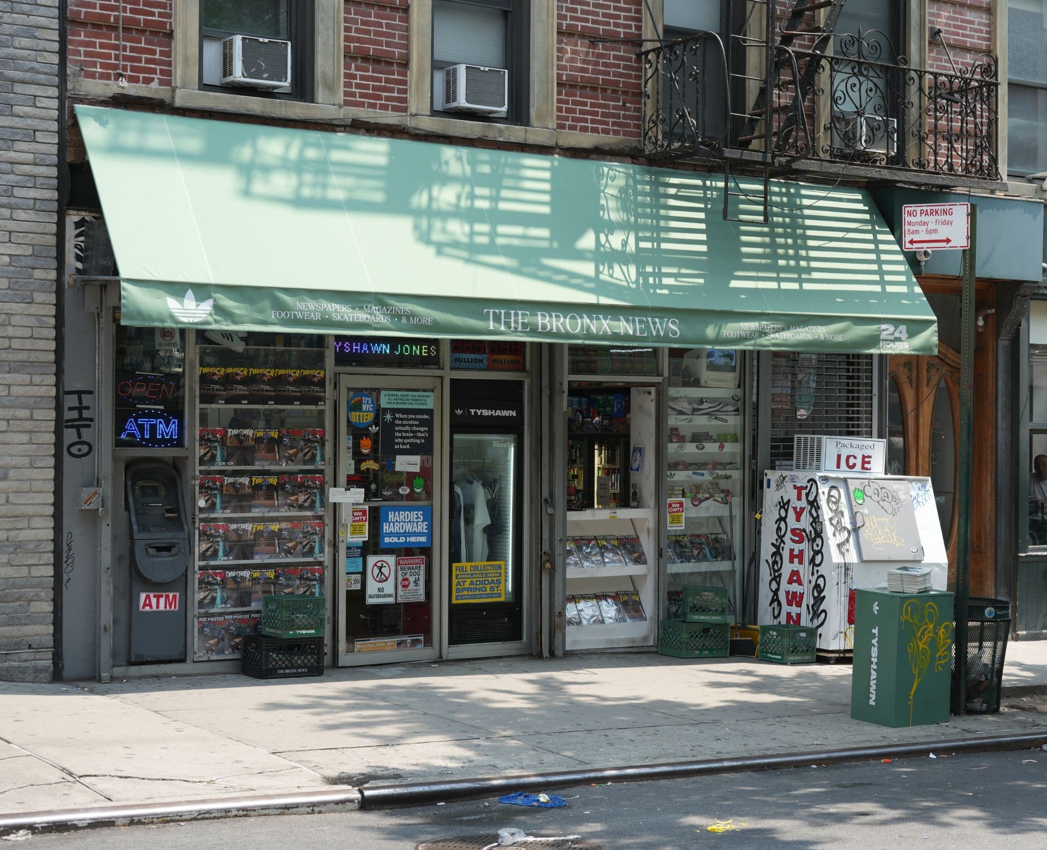 A street-level view of a storefront featuring a prominent green fabric awning.