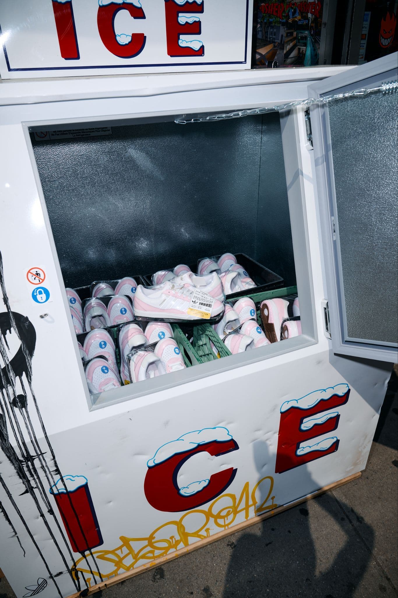 A white "ICE" vending machine with the door open showing bags of ice inside.