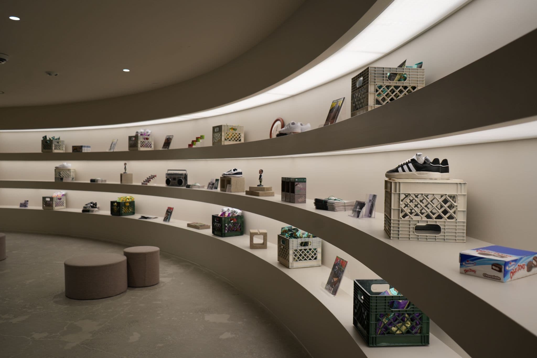 shelving.webp	Modern retail interior featuring minimalist curved white shelving displaying various objects.