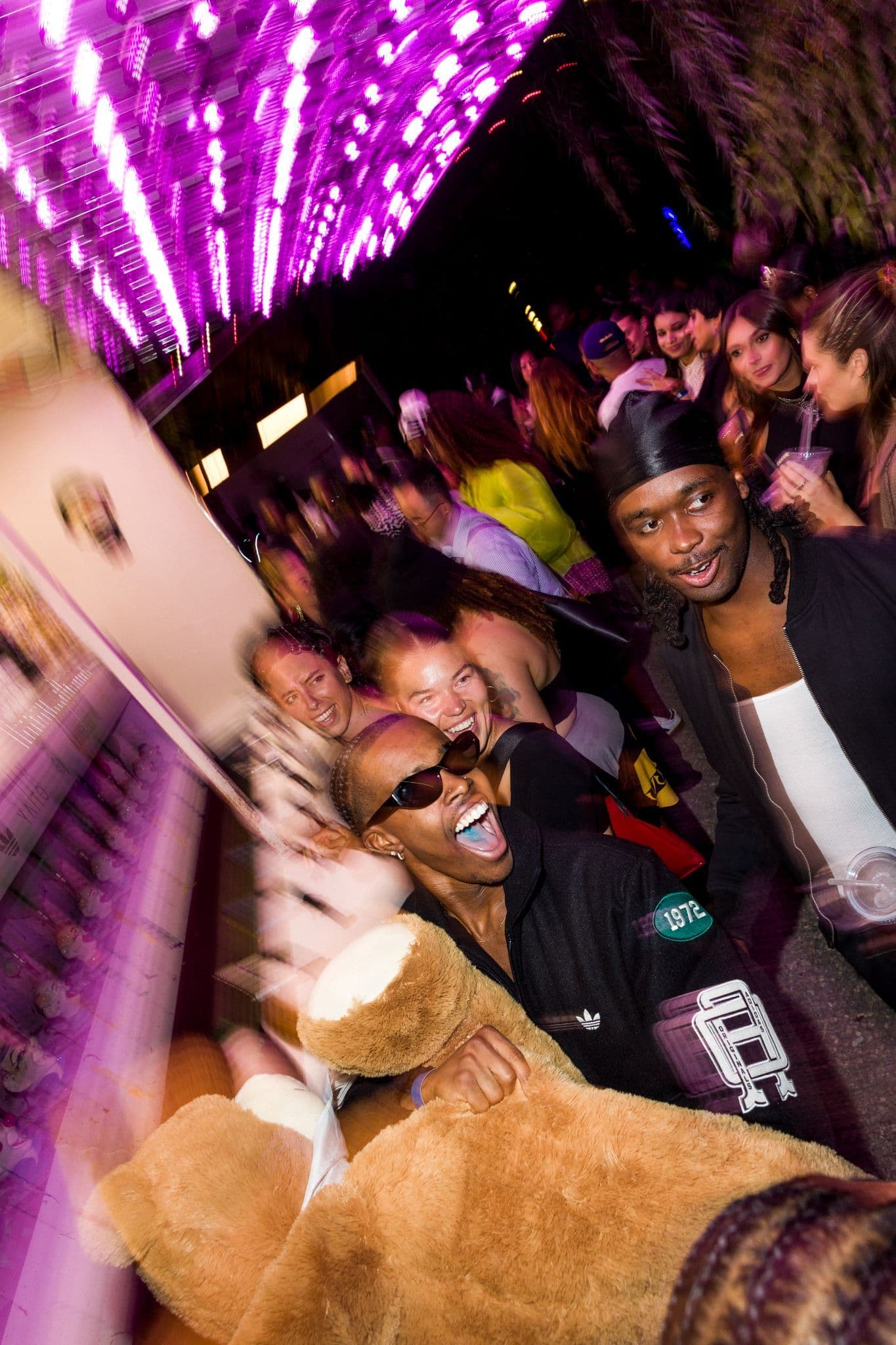 Close-up of guests enjoying the festive carnival atmosphere at the adidas NYFW party.