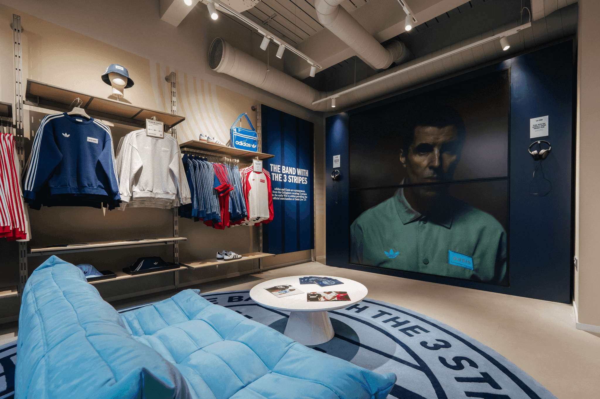 A blue lounge sofa in a curated retail space featuring large-scale portraits and apparel racks.
