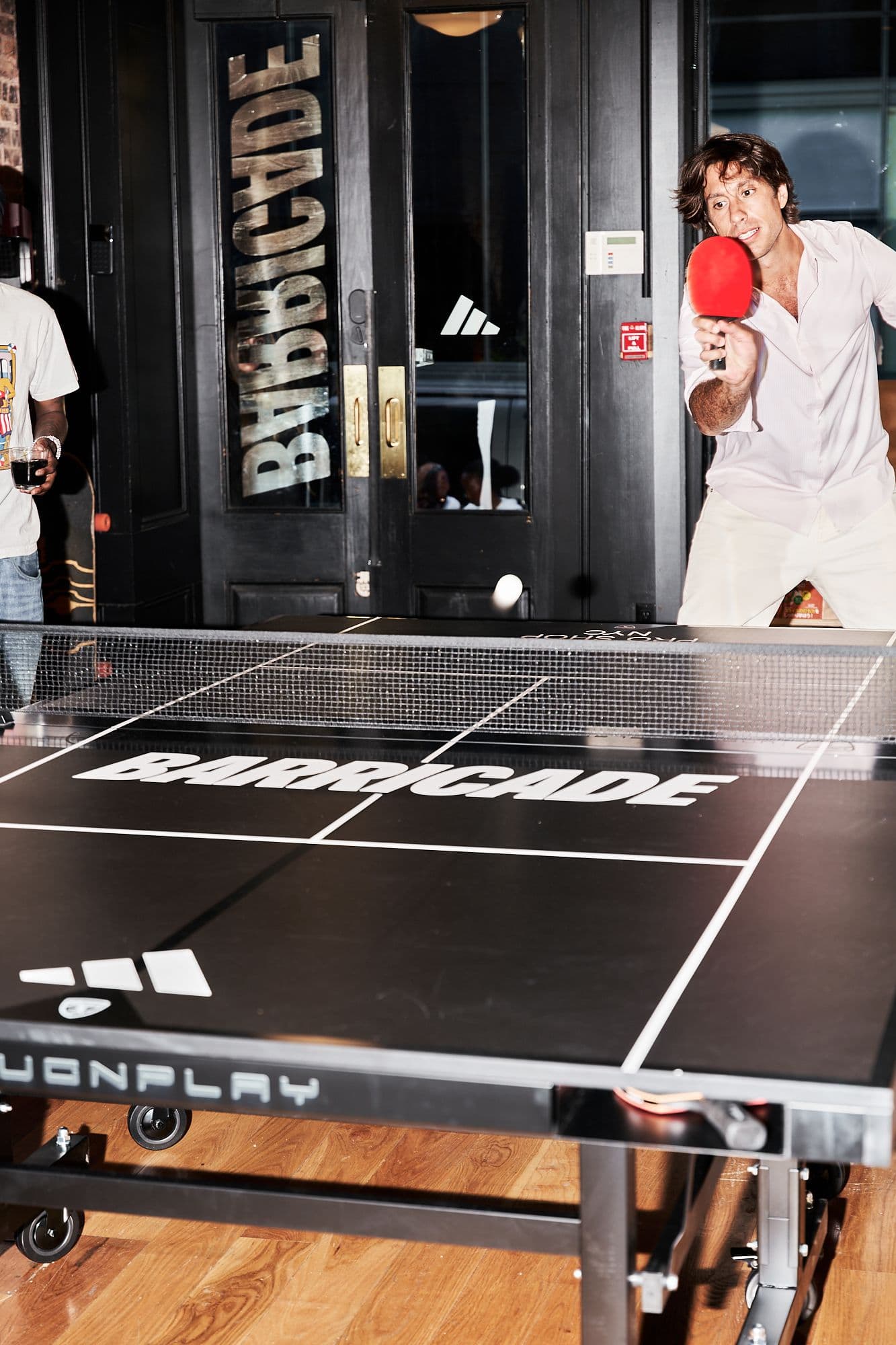 Guests playing table tennis on a branded table inside the archive exhibition.