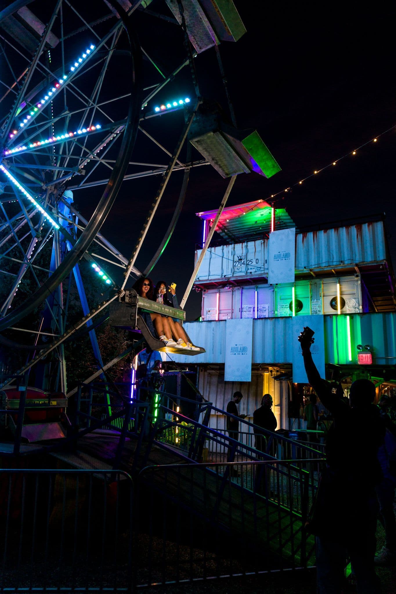 Full-scale Ferris wheel illuminated at night during the adidas Adiland event in NYC.