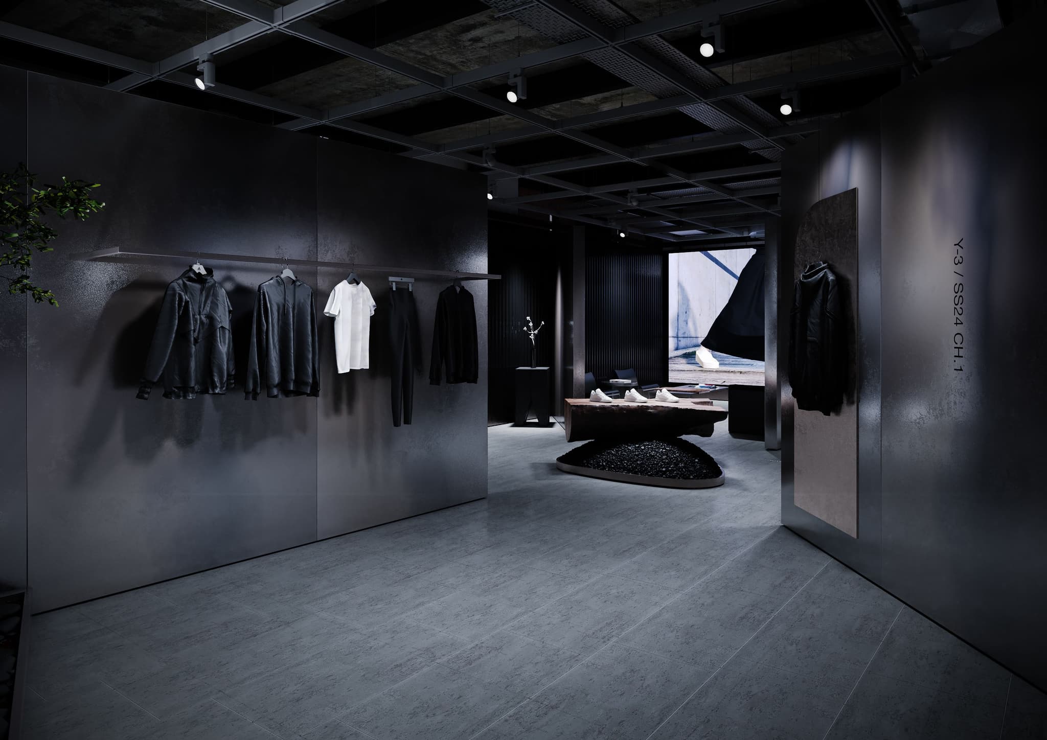 Wide view of an industrial Y-3 retail store with metal walls, hanging apparel, and a large wooden display table.