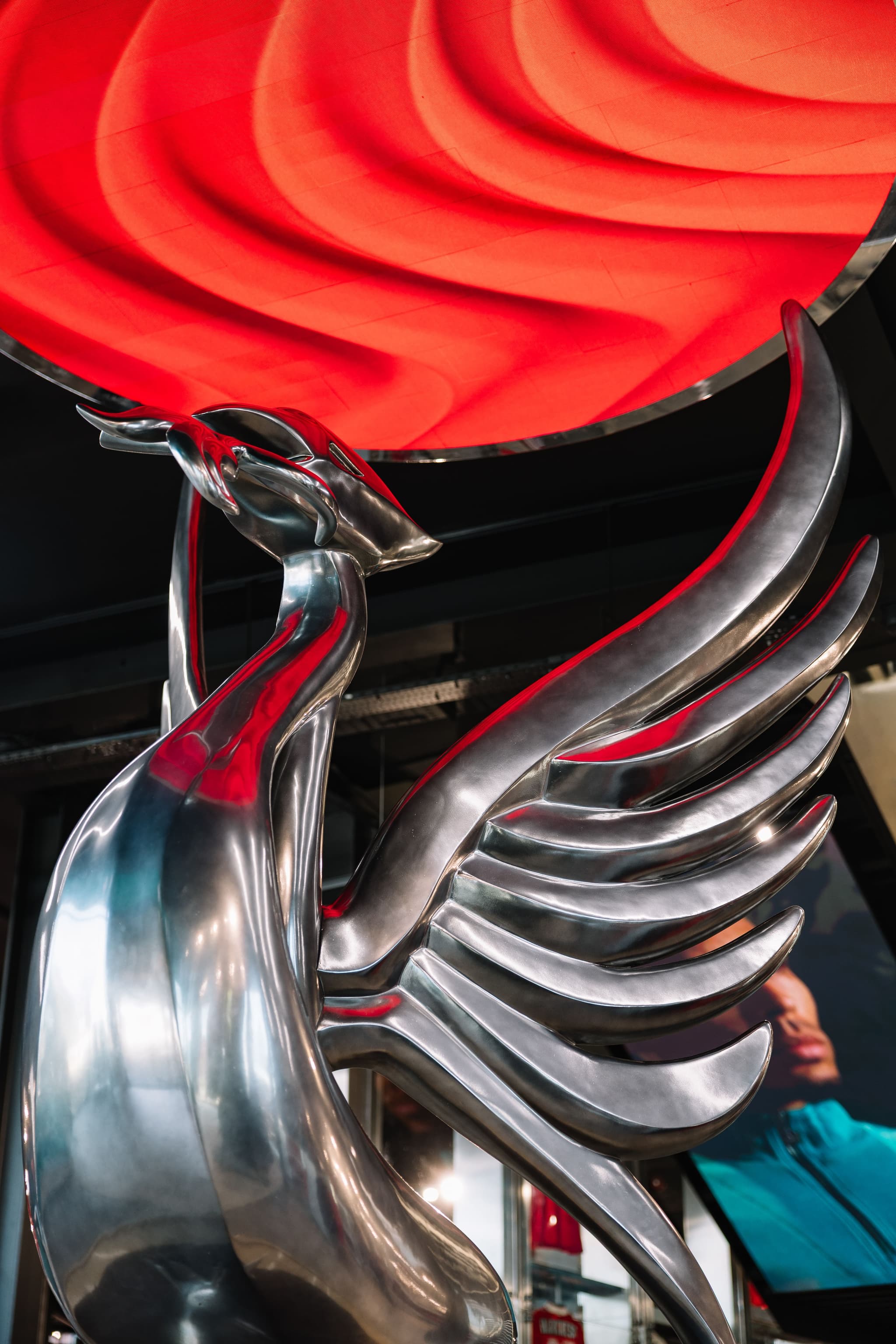 Close-up of a silver Liver Bird statue inside a Liverpool FC retail store.