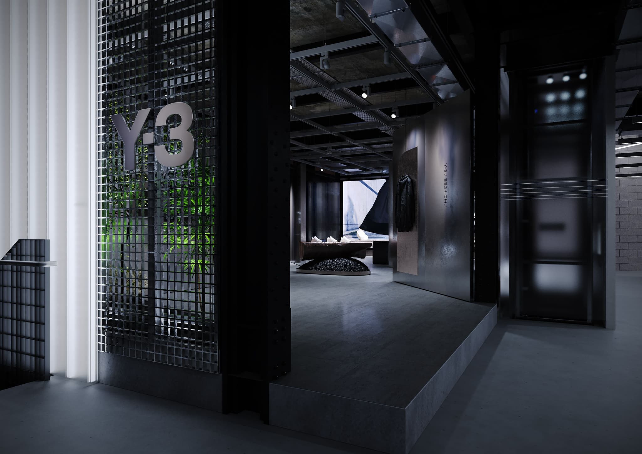 Entrance to a dark, industrial Y-3 store showing metal grating, steel walls, and a wooden display table.