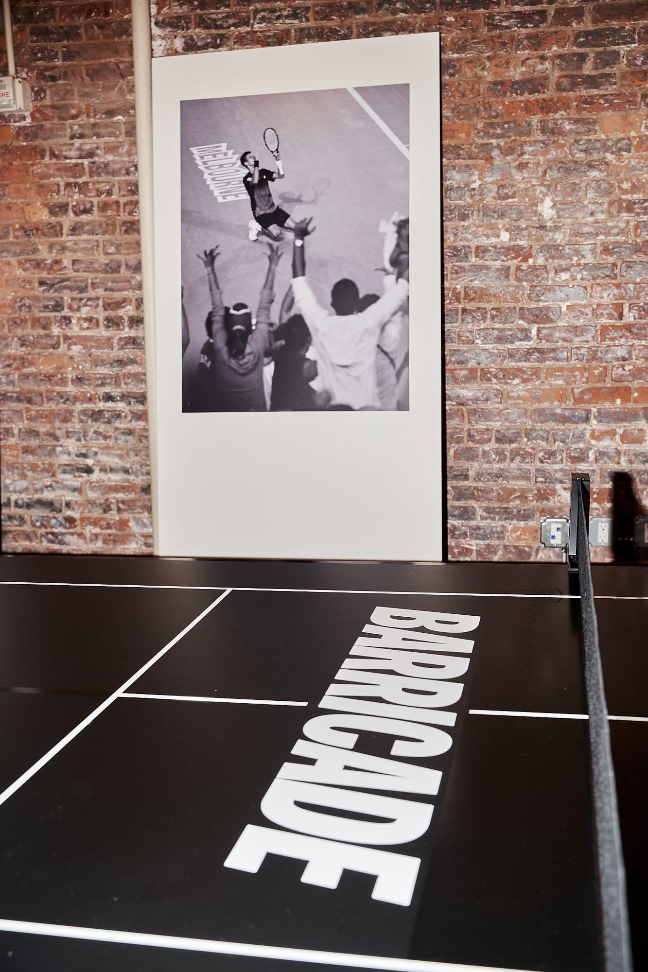 Large "BARRICADE" branding on the floor next to a tall vertical product imagery display.