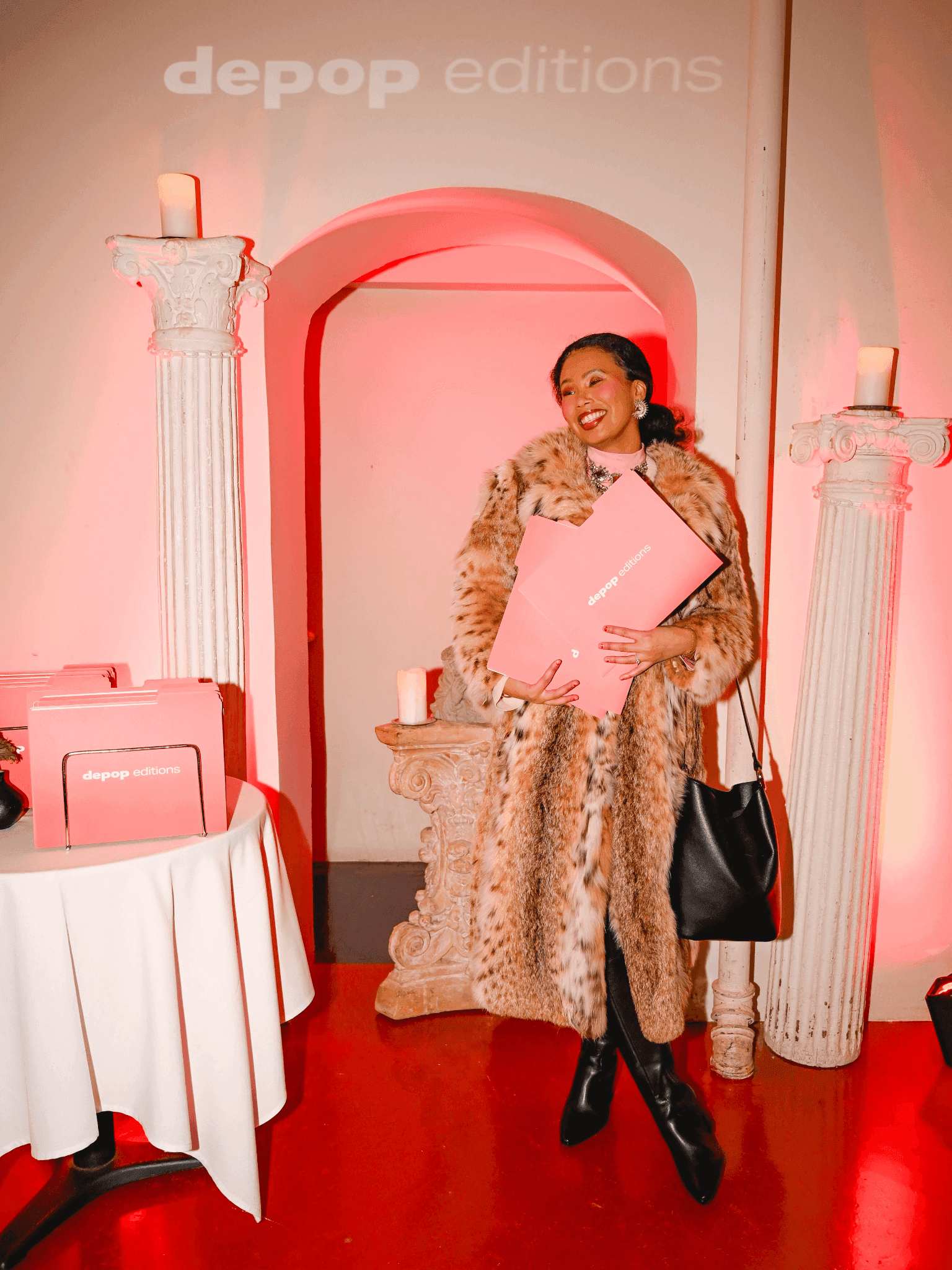 An attendee posing in front of a Depop branded pink archway and display.