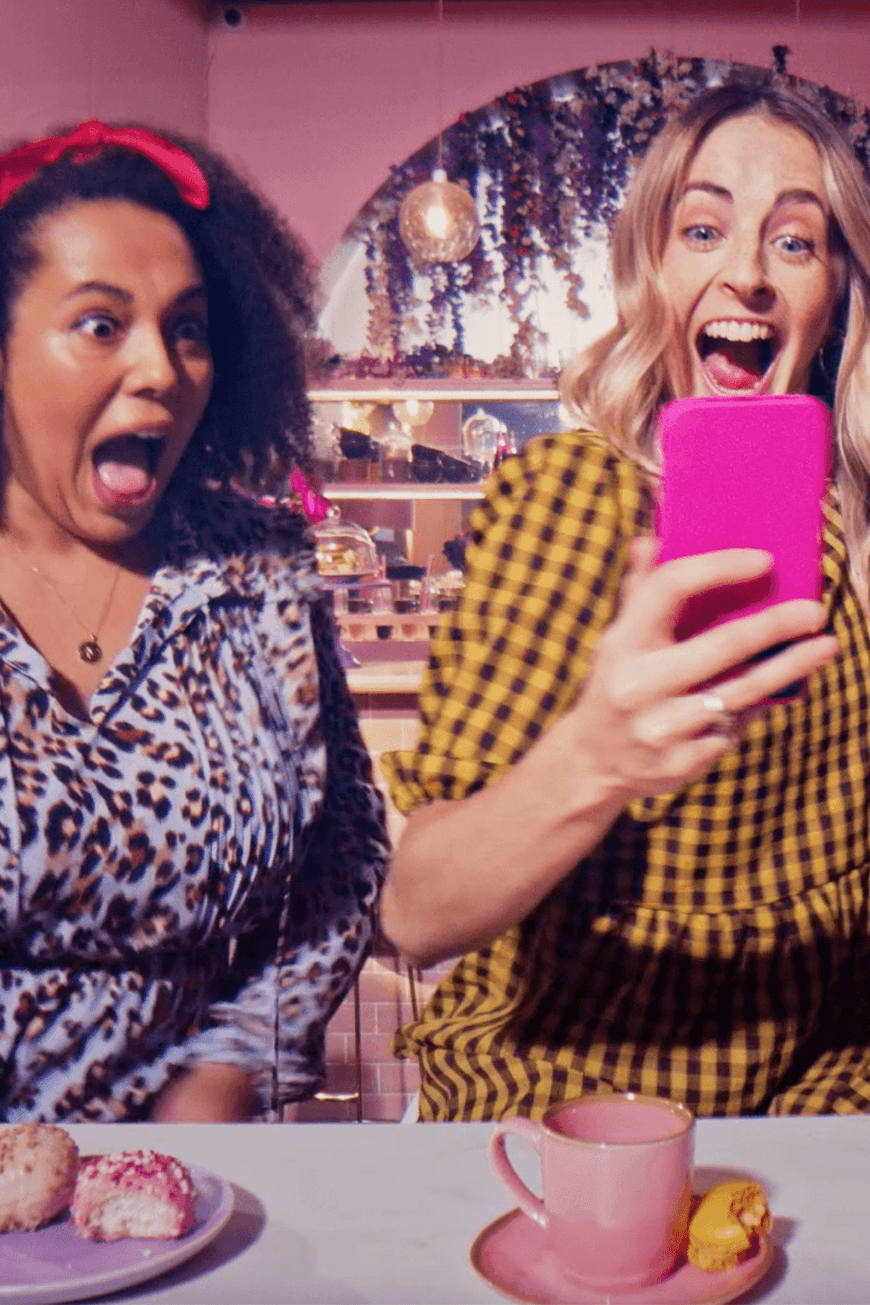 two women excited by phone